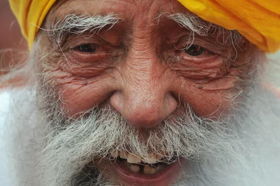 (FILES) Indian-born British national Fauja Singh speaks to the media after crossing the finish line in the 10-km event as part of the Hong Kong Marathon on February 24, 2013. India's Fauja Singh, believed to be the world's oldest distance runner, has died in a road accident aged 114, his biographer said on July 15, 2025. (Photo by Dale DE LA REY / AFP)<!-- NICAID(16080664) -->