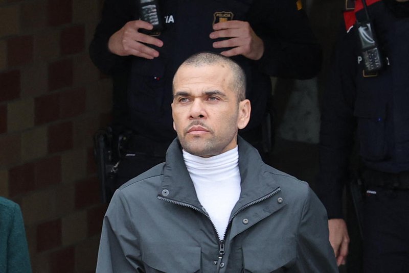 Prison workers unions' members protest over the killing of a cook by an inmate the week before, as convicted rapist and former Brazil international football player Dani Alves (R), flanked by his lawyer Ines Guardiola, leaves Brians 2 prison in San Esteban Sasrovirass, near Barcelona, on March 25, 2024. Convicted rapist and former Brazil international Dani Alves left a jail in Barcelona on March 25, 2024 after posting the one-million-euro bail set by a Barcelona court to ensure his release pending appeal. Ex-Brazil star has been sentenced to 4.5 years in jail for rape on February 22, 2024. (Photo by LLUIS GENE / AFP)Editoria: CLJLocal: San Esteban SasrovirasIndexador: LLUIS GENESecao: soccerFonte: AFPFotógrafo: STF<!-- NICAID(15715327) -->