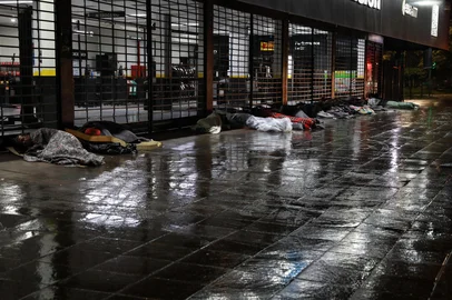 Porto Alegre, RS, Brasil - Na capital, moradores em situação de rua buscam abrigo sob a marquise de uma loja na Avenida Ipiranga, junto à Excelsior, para se proteger da chuva e do frio que marcaram os últimos dias na capital. Sem acesso a estruturas adequadas, recorrem a cobertores, lonas e improvisos enquanto a cidade enfrenta mais uma onda de baixas temperaturas."<!-- NICAID(16061393) -->