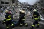 Rescuers carry a body taken from the rubble of a residential building destroyed after a missile strike, in Dnipro on January 15, 2023, amid the Russian invasion of Ukraine. - The death toll rose to at least 20 on January 15 after a strike on a residential building in Dnipro on January 14, a city in centre-east Ukraine, the Ukrainian regional governor said. (Photo by SERGEI CHUZAVKOV / AFP)<!-- NICAID(15321920) -->
