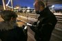 A security personnel member checks a health pass of a member of the public entering a Christmas market in Ajaccio, on the French Mediterranean island of Corsica, on December 7, 2021, as the region sees a hike of Covid-19 infections. (Photo by Pascal POCHARD-CASABIANCA / AFP)<!-- NICAID(14969716) -->