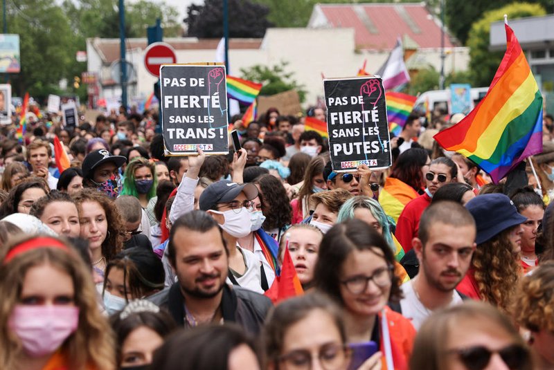 Participants hold signs reading "No pride without trans" as they take part at the annual Pride March parade in Paris on June 26, 2021. (Photo by THOMAS COEX / AFP)<!-- NICAID(14819818) -->