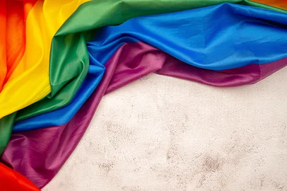 Pride month. Rainbow flag or LGBT is on a cement floor background. Space for text. Flat layFonte: 509725135<!-- NICAID(15164232) -->