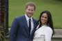 Príncipe Harry e Meghan Markle posam para fotos logo após anunciarem o noivadoBritain's Prince Harry stands with his fiancée US actress Meghan Markle as she shows off her engagement ring whilst they pose for a photograph in the Sunken Garden at Kensington Palace in west London on November 27, 2017, following the announcement of their engagement.Britain's Prince Harry will marry his US actress girlfriend Meghan Markle early next year after the couple became engaged earlier this month, Clarence House announced on Monday. / AFP PHOTO /<!-- NICAID(13292641) -->