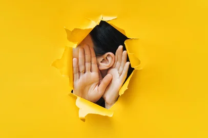Female ear and hands close-up. Copy space. Torn paper, yellow background. The concept of eavesdropping, espionage, gossip and the yellow press.Female ear and hands close-up. Copy space. Torn paper, yellow background. The concept of eavesdropping, espionage, gossip and the yellow press. Foto: shchus  / stock.adobe.comFonte: 285286400<!-- NICAID(16078412) -->