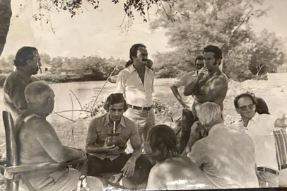 Anápio Linck está sem camisa.A cidade de São Leopoldo convive com as cheias do Rio dos Sinos desde a sua fundação, em 1824, quando chegaram as primeiras famílias de colonos alemães. Os prejuízos provocados pela grande enchente de 1965 mobilizaram a comunidade em busca de uma solução para proteger as áreas urbanas. Com ajuda técnica e financeira do governo da Alemanha Ocidental, as obras do sistema de diques tiveram início em 1974.O leitor Anápio Linck, 87 anos, contribui com uma imagem histórica. A fotografia e as informações foram enviadas ao Almanaque Gaúcho por sua filha, Bianca Stumpf Linck Uhf.O registro mostra um encontro de representantes da prefeitura, entre eles o então prefeito Henrique da Costa Prieto, com proprietários da Olaria Linck e da fábrica Papelão Justo, localizadas na Rua Luiz Pedro Daudt, às margens do Rio dos Sinos.A família Linck doou áreas de terra para a construção dos diques, de casas de bombas e de valas de drenagem. <!-- NICAID(16203778) -->