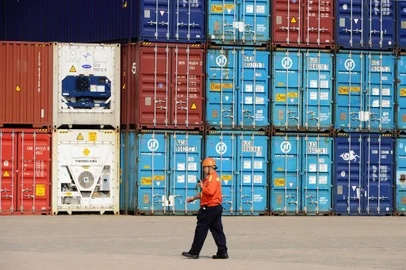 This picture taken on October 11, 2014 shows a worker walking past containers waiting to be transported in a port in Qingdao, east China's Shandong province. China's exports and imports both rose more than expected in September, Customs data showed in a positive signal for the world's second-largest economy, but analysts warned that fundamentals remained weak. CHINA OUT     AFP PHOTO<!-- NICAID(10906459) -->