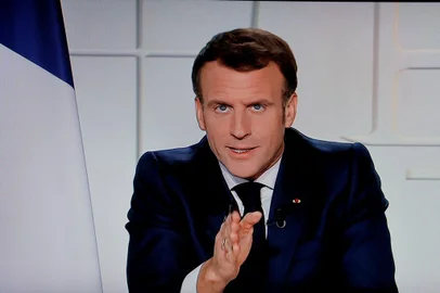O presidente francês Emmanuel Macron é visto em uma tela de TV enquanto fala durante um discurso televisionado sobre as novas restrições Covid-19 do Palácio do Eliseu em Paris em 31 de março de 2021. (Foto de Ludovic MARIN / AFP)<!-- NICAID(14748015) -->