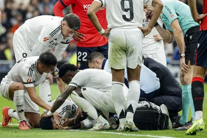 Teammates check on Real Madrid's Brazilian defender #03 Eder Militao (BOTTOM) after resulting injured during the Spanish league football match between Real Madrid CF and CA Osasuna at the Santiago Bernabeu stadium in Madrid on November 9, 2024. (Photo by OSCAR DEL POZO / AFP)<!-- NICAID(15910743) -->
