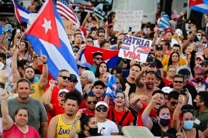 EVA MARIE UZCATEGUI / AFP People demonstrate, some holding Cuban and US National flags and placards, during a protest against the Cuban government in Miami on July 11, 2021. - Thousands of Cubans across the country took part in rare protests July 11, 2021, against the communist government, marching through several towns chanting, "Down with the dictatorship" and "We want liberty." The demonstrations started spontaneously in the morning, as the country endures its worst economic crisis in 30 years. The only authorized gatherings are normally Communist Party events. (Photo by Eva Marie UZCATEGUI / AFP)<!-- NICAID(14831971) -->