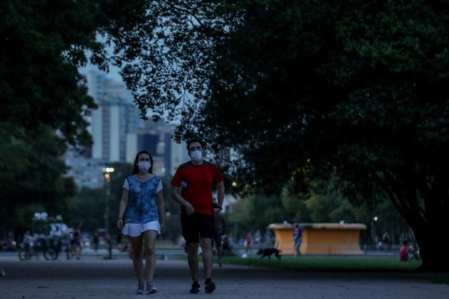 PORTO ALEGRE, RS, BRASIL - 25/01/2022Com calor, pessoas têm aproveitado as praças à noite. Na foto,  Lais Caramori e Mateus Veiga caminham no Parque da Redenção<!-- NICAID(14998739) -->