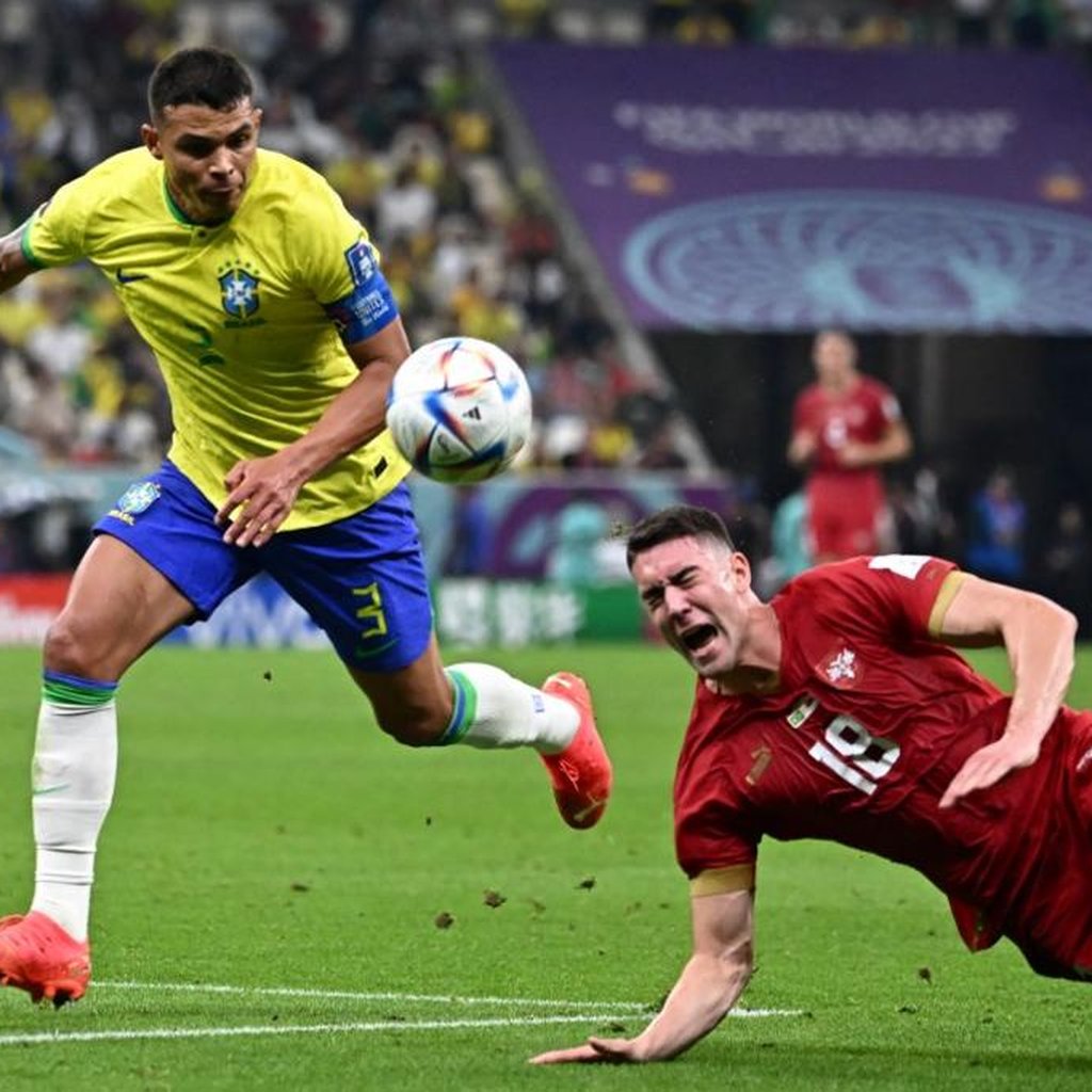 Dois jogadores de futebol jogando futebol no campo marcando um