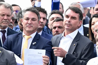 EVARISTO SA / AFP Brazilian Senator Flavio Bolsonaro (C) speaks during a press conference held by opposition lawmakers in support of former Brazilian President Jair Bolsonaro in front of the National Congress in Brasilia on August 5, 2024. A Brazilian judge on August 4 placed former president Jair Bolsonaro under house arrest for breaking a social media ban, escalating a dramatic standoff between the court and the politician, who is accused of plotting a coup. (Photo by EVARISTO SA / AFP)Editoria: POLLocal: BrasíliaIndexador: EVARISTO SASecao: parliamentFonte: AFPFotógrafo: STF<!-- NICAID(16094695) -->