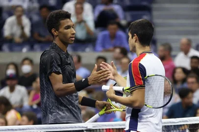 NEW YORK, NEW YORK - SEPTEMBER 07: (L-R) Felix Auger-Aliassime of Canada and Carlos Alcaraz of Spain meet at center court after Alcaraz retired early during the second set of their Mens Singles quarterfinals match on Day Nine of the 2021 US Open at the USTA Billie Jean King National Tennis Center on September 07, 2021 in the Flushing neighborhood of the Queens borough of New York City.   Matthew Stockman/Getty Images/AFP (Photo by MATTHEW STOCKMAN / GETTY IMAGES NORTH AMERICA / Getty Images via AFP)<!-- NICAID(14883733) -->