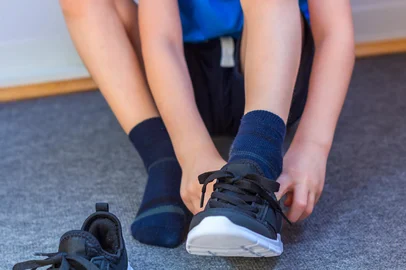 Child put on a pair of sneakers. Young boy's legs in textile fashion black sneakers. Children's trendy casual outfit and street fashion. Close upFonte: 334936183<!-- NICAID(16179354) -->