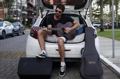 TORRES, RS, BRASIL, 24-01-2026: O músico Beto Rosa no carro onde passou a morar durante a temporada de apresentações no Litoral Norte. De Lajeado, ele retirou os bancos do veículo e improvisou ali um dormitório. À noite, se apresenta em bares e restaurantes de Torres. Foto: Mateus Bruxel/Agência RBSIndexador: MATEUS BRUXEL<!-- NICAID(16212414) -->