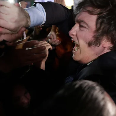 Argentine far-right libertarian economist and presidential candidate Javier Milei (R) celebrates with fans at the headquarters in Buenos Aires on August 13, 2023. The far-right libertarian economist Javier Milei gets 32.31% of the votes in the primaries for the Argentine presidential election, and becomes the protagonist of this election that will contest the former Security Minister Patricia Bullrich and the Economy Minister Sergio Massa. (Photo by ALEJANDRO PAGNI / AFP)<!-- NICAID(15509432) -->