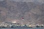 (FILES) This file picture taken on November 19, 2021 from Israel's southern Red Sea port and resort city of Eilat shows a view of the Flag of the Arab Revolt (top to bottom: black, green, and white stripes with a red chevron) flying in Jordan's nearby coastal city of Aqaba. - Israeli and Palestinian representatives held a meeting in the Red Sea resort of Aqaba on February 26, according to Jordanian state broadcaster al-Mamlaka, "the first of its kind in years" with regional and international participation to address "the situation in the Palestinian territories". (Photo by AHMAD GHARABLI / AFP)<!-- NICAID(15360074) -->