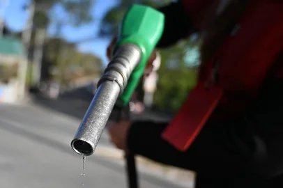 An attendant holds a fuel pump at a gas station in Tegucigalpa on March 9, 2026. The prices of petroleum derivatives soared on March 9 in Honduras due to the war in the Middle East. (Photo by Orlando SIERRA / AFP)<!-- NICAID(16242056) -->