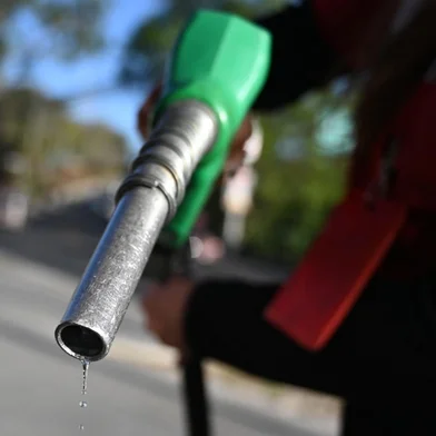 An attendant holds a fuel pump at a gas station in Tegucigalpa on March 9, 2026. The prices of petroleum derivatives soared on March 9 in Honduras due to the war in the Middle East. (Photo by Orlando SIERRA / AFP)<!-- NICAID(16242056) -->