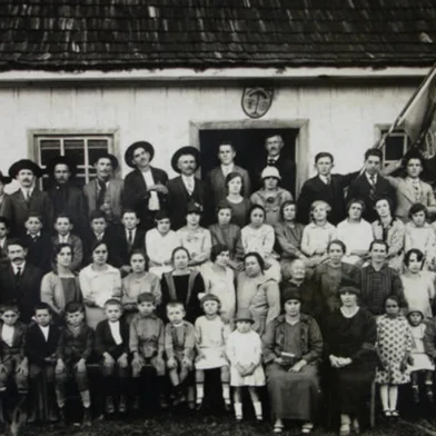 Escola Municipal de São Luiz na Terceira Légua - Caxias do Sul, em 1930. Estão reunidos pais, alunos, professores e autoridades. Na primeira fila, sentadas, da esquerda para a direita, as professoras Maria Foppi e Maria Prezzi Postali.Fonte: B3459, doação de Aparício Postali, Arquivo Histórico Municipal João Spadari Adami.<!-- NICAID(16036517) -->