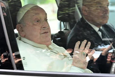 Pope Francis waves as he leaves the Gemelli hospital after a five weeks hospitalization for pneumonia, in Rome on March 23, 2025. Pope Francis is to leave hospital todayand return to his residence in the Vatican, where he is to spend "at least two months" recovering, one of his doctors announced during a press conference on March 22, 2025. (Photo by Tiziana FABI / AFP)<!-- NICAID(16001467) -->