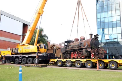 Em uma grande operação nesta quarta e quinta-feira (02 e 03/07), que contou com guinchos, carretas e profissionais de empresas parceiras da Prefeitura de Caxias, a locomotiva a vapor, fabricada em 1921, voltou para a Estação Férrea.Com cerca de 80 toneladas, foi necessário construir parte de um trilho para locomover o trem, há 20 anos parado na Ulbra, em Canoas, e dois grandes caminhões guinchos para colocá-lo em cima de duas carretas plataforma, que realizaram o transporte nesta manhã até Caxias do Sul.Na metade da tarde, a nova atração já estava novamente nos trilhos, por onde ela esteve décadas atrás. O Prefeito Adiló Didomenico e a Vice-prefeito Edson Néspolo estiveram na Estação Férrea. "É um grande presente para Caxias do Sul. Aqui está uma parte da história e do desenvolvimento que foi muito importante. Caxias, uma parte do que ela é hoje, deve-se à rede ferroviária. Essa máquina é uma relíquia, uma das três que fez o trecho Caxias-Montenegro. Então ela tem um valor histórico imensurável. Com o passar do tempo, as pessoas do bem, as pessoas que desejam que Caxias vá pra frente, que Caxias conheça sua história, vão reconhecer. Eu não tenho dúvida que ela vem compor e ajudar todo cenário do bairro São Pelegrino, o complexo da Estação será um atrativo muito grande, isso que nós estamos apostando. Parabéns a todos que colaboraram no processo de trazer a locomotiva de volta", disse Adiló.O patrimônio, que era do Departamento Nacional de Infraestrutura de Transportes (Dnit), foi doado ao Município. Entretanto, o município reservou R$ 500 mil para custear despesas necessárias para reparar possíveis danos ocasionados pela sua retirada da Ulbra. A universidade está fazendo o levantamento dos estragos. A próxima etapa é a busca empresas parceiras para realizar a recuperação do patrimônio.A Prefeitura de Caxias do Sul aceitou a doação da locomotiva, que tem valor estimado em R$ 2,4 milhões, porque ela faz parte da história da cidade e será um atrativo turístico e cultural, juntamente com toda a revitaliação da Estação Férrea, que está em fase final.<!-- NICAID(16072937) -->