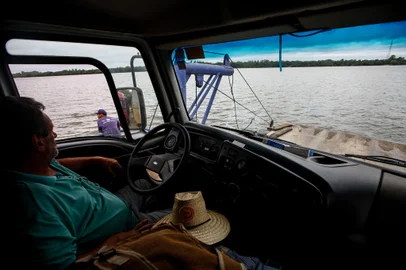 Triunfo, RS, Brasil, 18/01/2023 - Travessia de balsa pelo rio Jacuí entre os municípios de Triunfo e São Jerônimo é opção para encurtar trajeto, enquanto não há ponte na região. Na foto, Agenor Toscan, 62, caminhoneiro na área de construção civil. Primeira vez que utiliza a balsa. - Foto: Jonathan Heckler/Agência RBS<!-- NICAID(15324617) -->