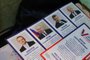 A leaflet displaying presidential candidates is seen on a table as local residents vote in their apartment during early voting for Russia's presidential election in Oktyabrsky, Belgorod region, on March 10, 2024. (Photo by STRINGER / AFP)<!-- NICAID(15705324) -->