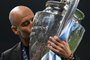 Manchester City's Spanish manager Pep Guardiola kisses the European Cup trophy as they celebrate winning the UEFA Champions League final football match between Inter Milan and Manchester City at the Ataturk Olympic Stadium in Istanbul, on June 10, 2023. Manchester City won the match 1-0. (Photo by Paul ELLIS / AFP)<!-- NICAID(15453040) -->