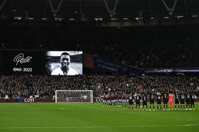 Players and officials observe a minute's silence to honour Brazilian football legend Pele, who died on December 29, ahead of the English Premier League football match between West Ham United and Brentford at the London Stadium, in London on December 30, 2022. - Pele passed away aged 82 after suffering "multiple organ failure" following a long battle with cancer and football's current and former stars were quick to salute arguably the sport's greatest ever player. (Photo by Ben Stansall / AFP) / RESTRICTED TO EDITORIAL USE. No use with unauthorized audio, video, data, fixture lists, club/league logos or 'live' services. Online in-match use limited to 120 images. An additional 40 images may be used in extra time. No video emulation. Social media in-match use limited to 120 images. An additional 40 images may be used in extra time. No use in betting publications, games or single club/league/player publications. / Editoria: SPOLocal: LondonIndexador: BEN STANSALLSecao: soccerFonte: AFPFotógrafo: STF<!-- NICAID(15308719) -->