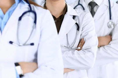 Group of modern doctors standing as a team with arms crossed in hospital office. Physicians ready to examine and help patients. Medical help, insurance in health care, best desease treatment and medicine conceptMédicos. Foto: Iryna / stock.adobe.comFonte: 296904883<!-- NICAID(15728330) -->