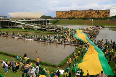 Supporters of Brazilian former President Jair Bolsonaro invade the National Congress in Brasilia on January 8, 2023. - Hundreds of supporters of Brazil's far-right ex-president Jair Bolsonaro broke through police barricades and stormed into Congress, the presidential palace and the Supreme Court Sunday, in a dramatic protest against President Luiz Inacio Lula da Silva's inauguration last week. (Photo by Sergio Lima / AFP)Editoria: WARLocal: BrasíliaIndexador: SERGIO LIMASecao: demonstrationFonte: AFPFotógrafo: STR<!-- NICAID(15315549) -->