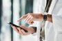 Hands, phone and man doctor typing message, social media or planning online schedule in a hospital. Telehealth, search and male healthcare expert with smartphone for advice, chat or research checkMãos usando telefone - Foto: Malik/peopleimages.com/stock.adobe.comIndexador: Yuri Arcurs peopleimages.comFonte: 627651726<!-- NICAID(15538375) -->