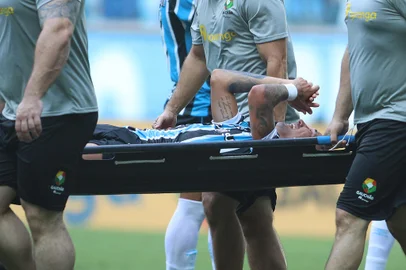 RS - FUTEBOL/CAMPEONATO GAÚCHO/GRÊMIO X SÃO LUIZ - ESPORTES - Jhonata Robert, do Grêmio, deixa o campo lesionao durante partida contra o São Luiz válida pela sétima rodada da   primeira fase do Campeonato Gaúcho 2024, realizada na Arena do Grêmio, em Porto Alegre, na tarde deste sábado   (10).   10/02/2024 - Foto: EDU ANDRADE/FATOPRESS/ESTADÃO CONTEÚDO<!-- NICAID(15675820) -->