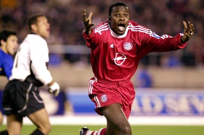 Samuel Kuffour, jogador de futebol do Bayern de Munique comemorando o gol da vitória sobre o Boca Juniors da Argentina em partida válida pelo Campeonato Mundial Interclubes 2001.Germany's Bayern Munich defender Samuel Kuffour celebrates after he scored a goal while Argentina's Boca Juniors goalie Oscar Eduardo Cordoba (L) looks on during the Toyota Cup, European/South American club championship in Tokyo 27 November 2001.  Bayern Munich defeated Boca Juniors 1-0.   AFP PHOTO/JIJI PRESSFDFoto não publicada Fonte: AFP Fotógrafo: -<!-- NICAID(812177) -->
