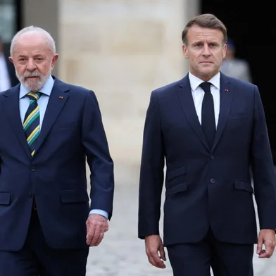 French President Emmanuel Macron (R) and Brazil's President Luiz Inacio Lula da Silva (L) review a guard of honour during an official welcoming ceremony at the Hotel des Invalides in Paris on June 5, 2025. (Photo by Sarah Meyssonnier / POOL / AFP)<!-- NICAID(16052805) -->