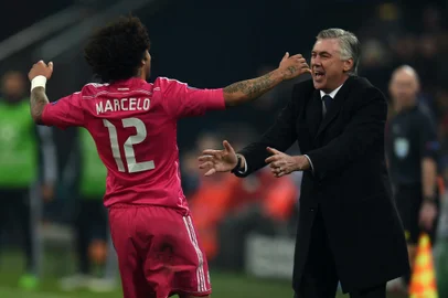 Real Madrid's Italian coach Carlo Ancelotti (R) and Real Madrid's Brazilian defender Marcelo celebrate after Marcelo scored during the last sixteen, first-leg UEFA Champions League football match FC Schalke 04 vs Real Madrid in Gelsenkirchen, western Germany on February 18, 2015. AFP PHOTO / PATRIK STOLLARZ<!-- NICAID(11207263) -->
