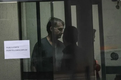 Jair Bolsonaro na PolÃ­cia Federal em BrasÃ­liaBRASÍLIA, DF, BRASIL, 23.11.2025: BOLSONARO-POLÍCIA FEDERAL-POLÍTICA - O ex-presidente Jair Bolsonaro é visto através do vidro da sede da Polícia Federal, em Brasília, durante sua permanência no local ao longo das investigações que motivaram sua condução. A cena mostra Bolsonaro no interior do prédio, observado pela equipe de segurança. (Foto: Gabriela Biló/Folhapress)<!-- NICAID(16172874) -->