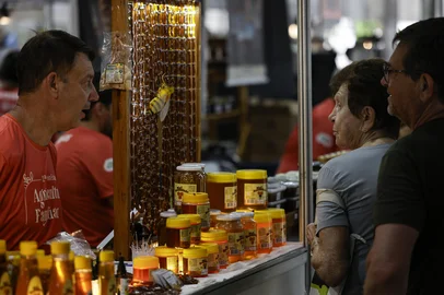 TORRES, RS, BRASIL, 30-01-2026: Ari Antônio de Conto (E) atende clientes no estande da Mel Encantado, de Encantado, na 12ª Feira da Agricultura Familiar em Torres, no Litoral Norte. Foto: Mateus Bruxel/Agência RBSIndexador: MATEUS BRUXEL<!-- NICAID(16215305) -->