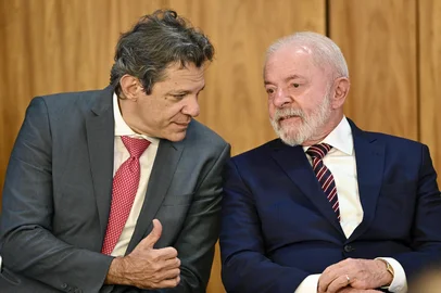 Brazil's President Luiz Inacio Lula da Silva (R) speaks with his Finance Minister Fernando Haddad during the signing of the new export incentive law at the Planalto Palace in Brasilia on July 28, 2025. (Photo by EVARISTO SA / AFP)Editoria: FINLocal: BrasíliaIndexador: EVARISTO SASecao: economy (general)Fonte: AFPFotógrafo: STF<!-- NICAID(16089651) -->