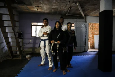 Porto Alegre, RS, Brasil, 31-03-2023: Wagner Kauê, 17, Érica Rayne, 17, o professor Jarbas Jesus Machado Cidade, e Wesley Kauãn, 17, no projeto Criança Capoeira Jiu-jitsu, no Porão dos Guerreiros, no bairro Bom Jesus. A iniciativa, que existe desde 2003, ensina de forma gratuita capoeira e jiu-jitsu para jovens de baixa renda da comunidade. Agora, quatro integrantes se qualificaram para o Campeonato Brasileiro de Jiu-Jitsu, em São Paulo, mas precisam de apoio, que estimam em cerca de 6 mil reais, para participar. Eles organizaram uma vaquinha virtual e estão vendendo rifas para arrecadar o valor. Foto: Mateus Bruxel / Agência RBS<!-- NICAID(15391010) -->