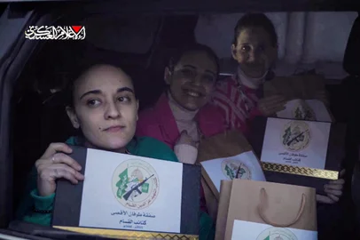 This image grab from a handout video released by the Hamas Media Office shows Israeli hostages (L to R) Emily Damari, Romi Gonen, and Doron Steinbracher, who were abducted by Palestinian militants during the October 7, 2023 attacks, posing with documents bearing the logo of the Ezzedine al-Qassam Brigades, Hamas's armed wing, certifying their release following the ceasefire and hostage-prisoner exchange deal in the war between Israel and Hamas, as they sit in a Hamas vehicle before being handed over to the International Committee of the Red Cross (ICRC) in the Gaza Strip on January 19, 2025. The first three Israeli hostages were released on January 19 under a long-awaited Gaza truce aimed at ending more than 15 months of war that has ravaged the Palestinian territory. (Photo by HAMAS MEDIA OFFICE / AFP) / == RESTRICTED TO EDITORIAL USE - MANDATORY CREDIT "AFP PHOTO / HO / HAMAS MEDIA OFFICE" - NO MARKETING NO ADVERTISING CAMPAIGNS - DISTRIBUTED AS A SERVICE TO CLIENTS ==<!-- NICAID(15956776) -->