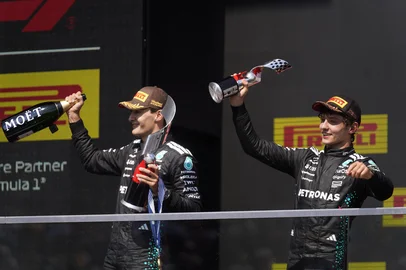 (L/R) Race winner Mercedes' British driver George Russell and teammate and third place finisher Kimi Antonelli celebrate on the podium after the 2025 Formula 1 Grand Prix du Canada at Circuit Gilles-Villeneuve in Montreal, Canada, on June 15, 2025. (Photo by Geoff Robins / AFP)<!-- NICAID(16065502) -->