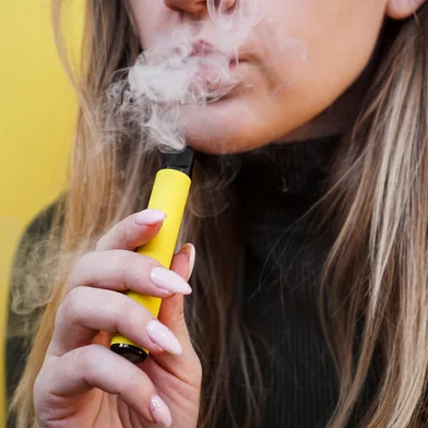 A young girl smokes disposable electronic cigarette. Bright yellow backgroundProibição dos cigarros eletrônicos deve ser mantida no Brasil - Foto: brillianata/stock.adobe.comFonte: 422942092<!-- NICAID(15621053) -->