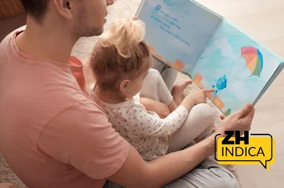 Father and his daughter reading book on floor in children room<!-- NICAID(16198346) -->