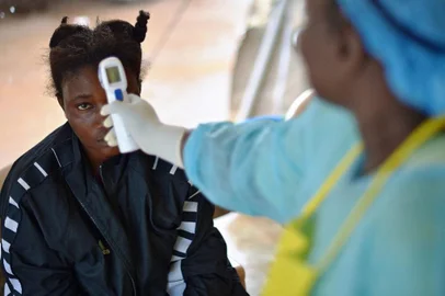 (FILES) this file photo taken on August 16, 2014 shows a girl suspected of being infected with the Ebola virus having her temperature checked at the government hospital in Kenema. - Four people have died of Ebola in Guinea, the first resurgence of the haemorrhagic fever in the West African nation since a 2013-2016 epidemic left thousands dead, Health Minister Remy Lamah said on February 13, 2021. (Photo by CARL DE SOUZA / AFP)<!-- NICAID(14714560) -->
