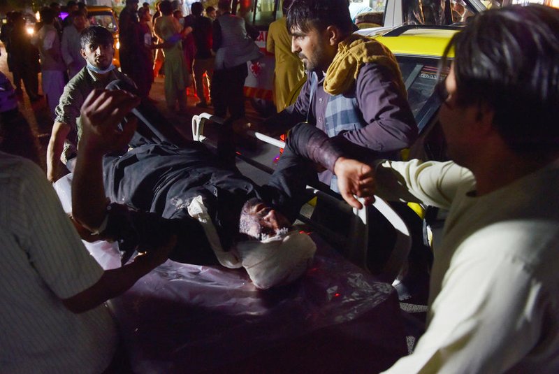 Medical and hospital staff bring an injured man on a stretcher for treatment after two blasts, which killed at least five and wounded a dozen, outside the airport in Kabul on August 26, 2021. (Photo by Wakil KOHSAR / AFP)<!-- NICAID(14873144) -->