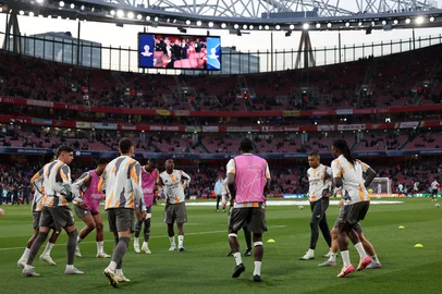 Real Madrid's Brazilian forward #07 Vinicius Junior (C) warms up ahead of the UEFA Champions League Quarter final first leg football match between Arsenal and Real Madrid, at the Emirates Stadium, in London, on April 8, 2025. (Photo by Adrian Dennis / AFP)<!-- NICAID(16012733) -->