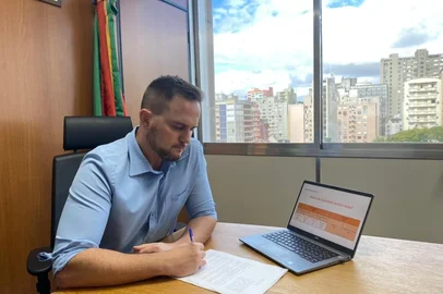 Fábio Ostermann assina PL de incentivo à educação - assinando o PL (crédito de Arthur Rodrigues/ALRS)